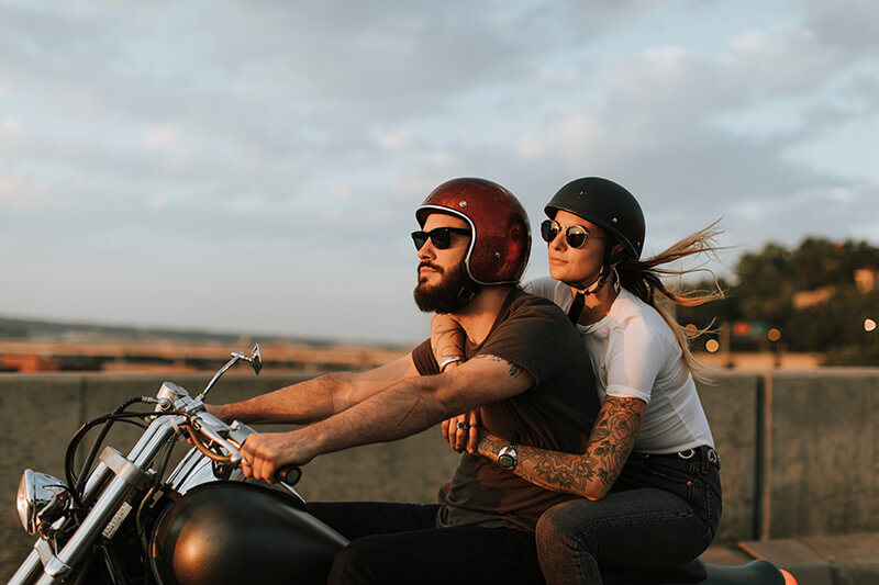 Couple on a motorbike, riding down the street