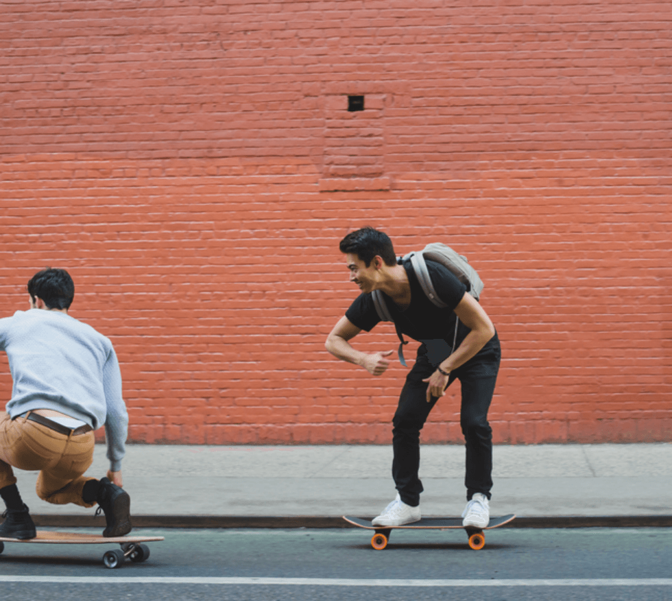 Two guys skateboarding down the road